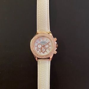 Rose gold watch on an off white leather band